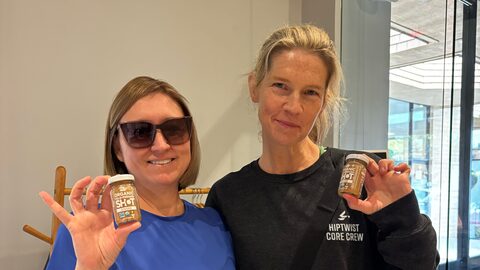 Two Hiptwist members smiling with juice shots at the Glow Hour Juice Bar, Hiptwist Fitness Studio, San Mateo