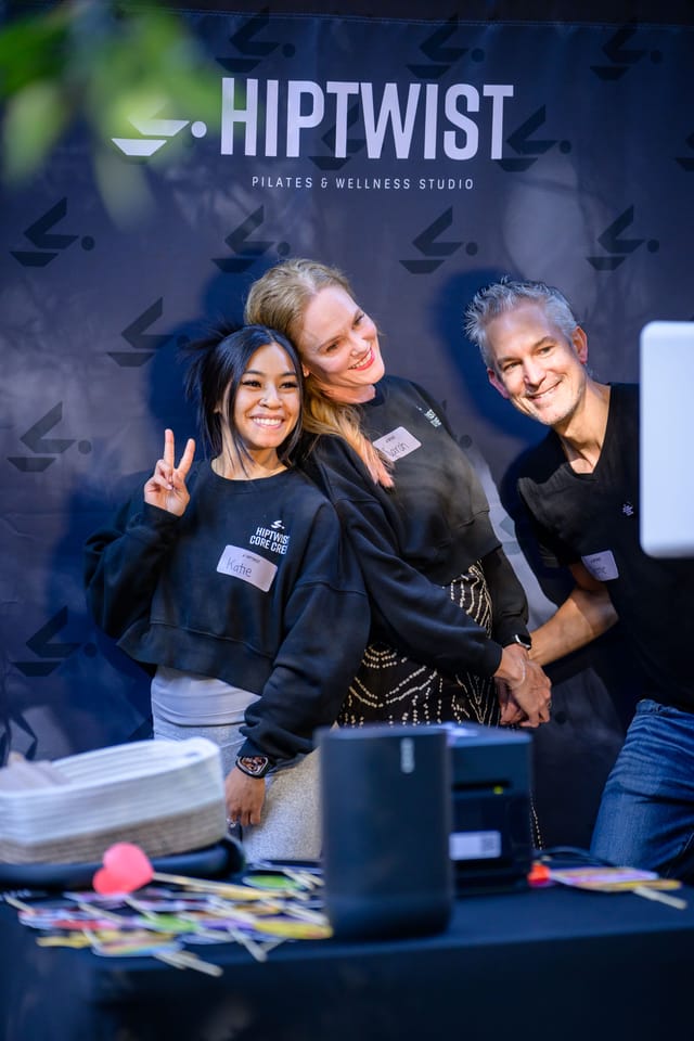 Sarah posing with two guests at the photo booth