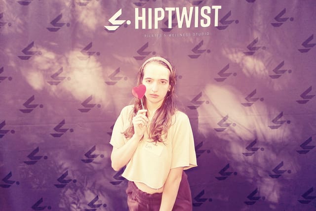 A guest holding a heart prop, in a dreamy purple filter