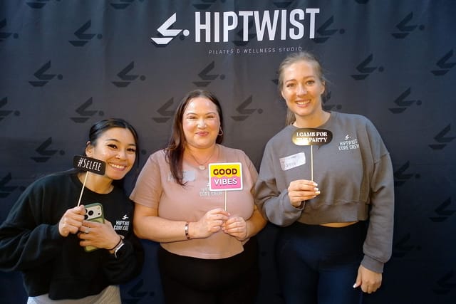 Three guests with photo booth signs