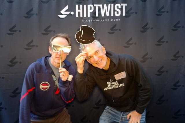 Two guests clowning with top hat and sunglasses props